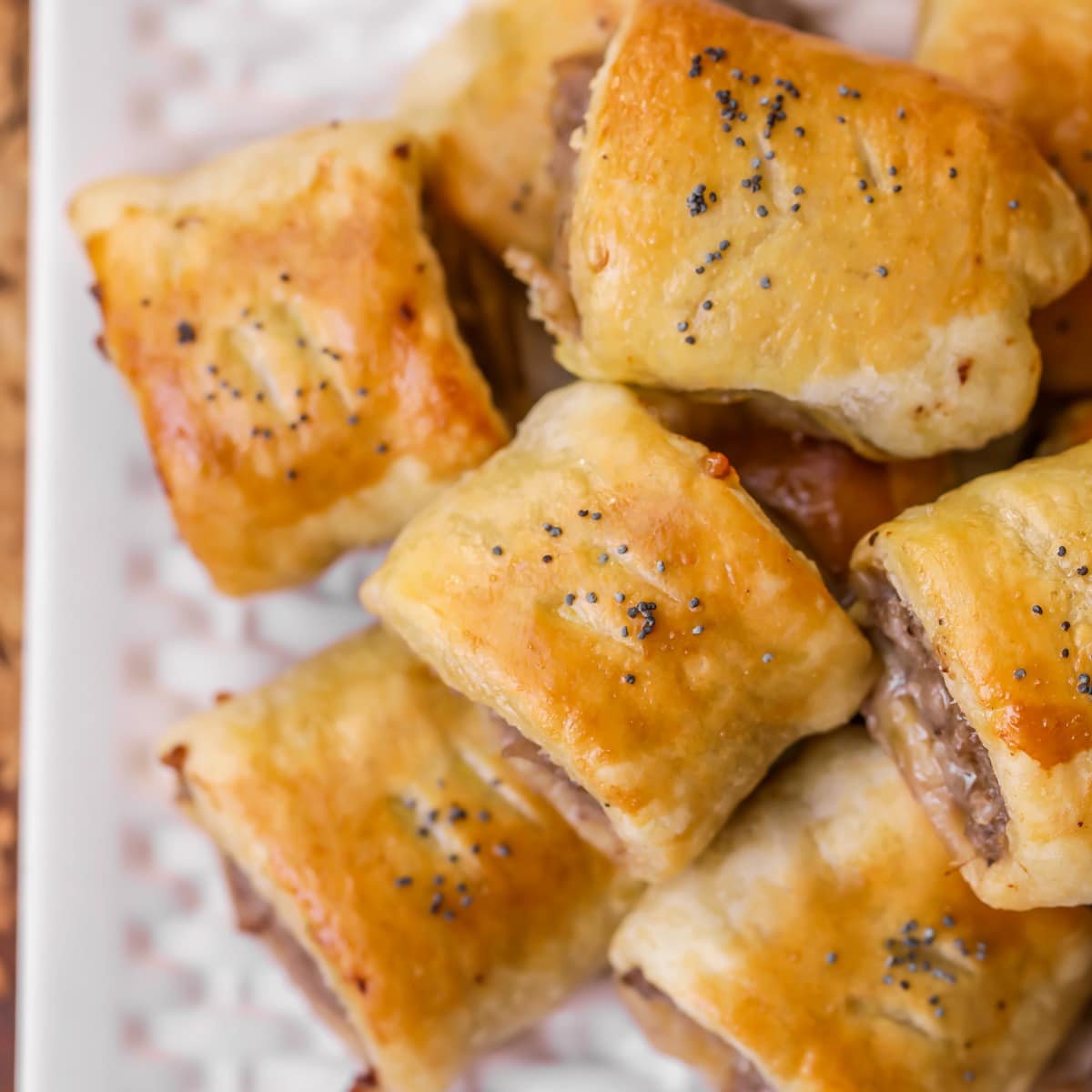 Puff Pastry Sausage rolls with poppy seeds on top.