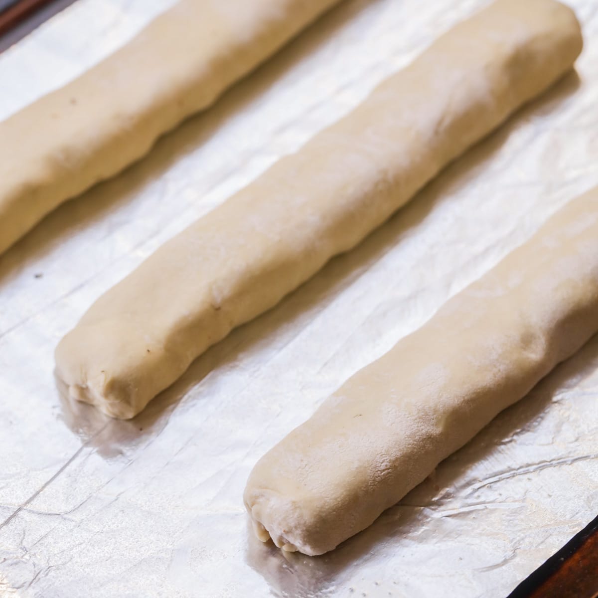 Step by step pictures of making puff pastry sausage rolls.