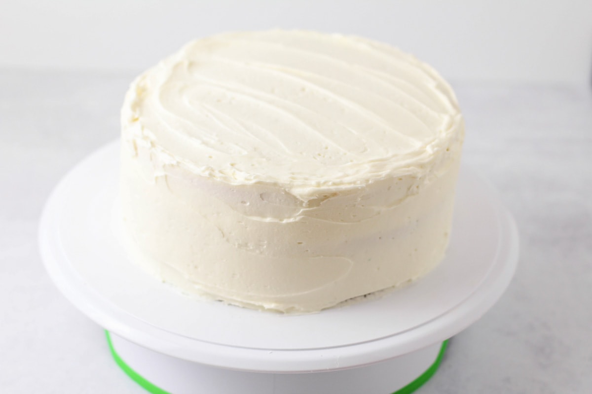 Cake frosted on cake stand.
