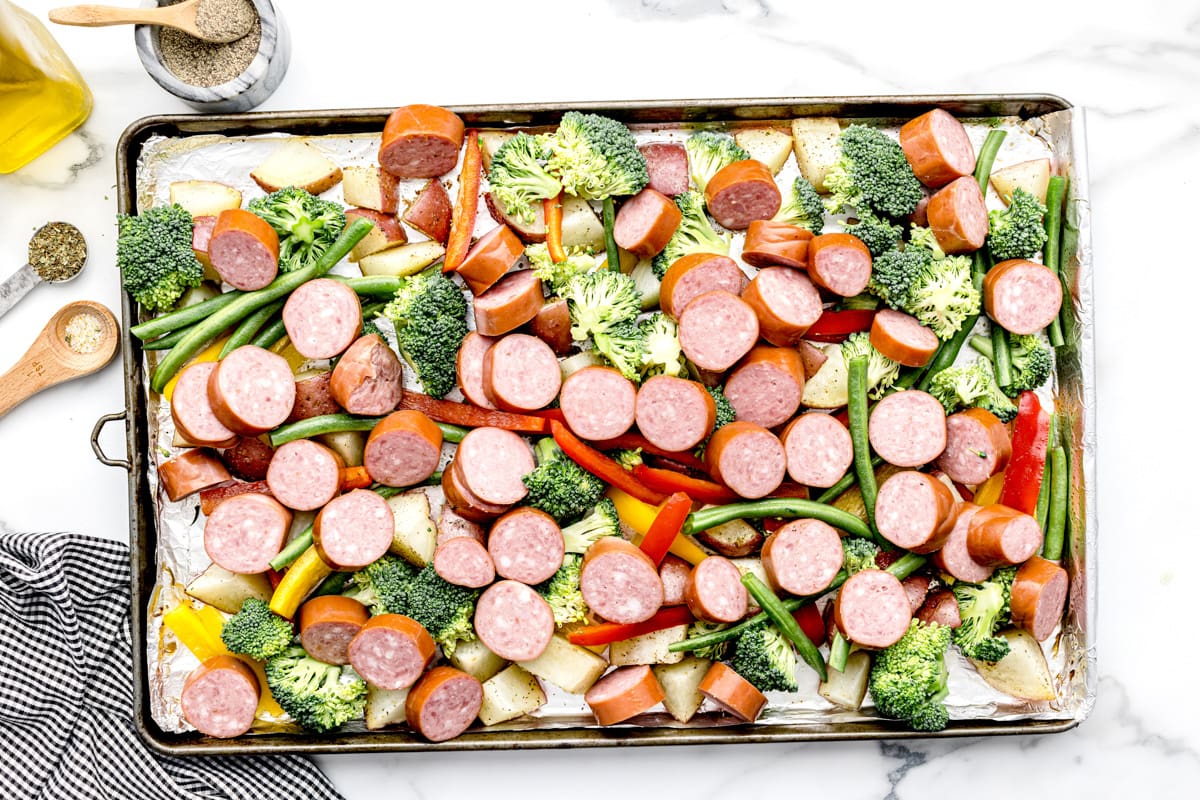 Sheet pan sausage and veggies on a baking sheet ready for baking.
