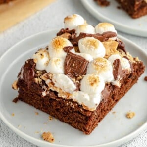 A slice of s'mores brownies on a white plate.
