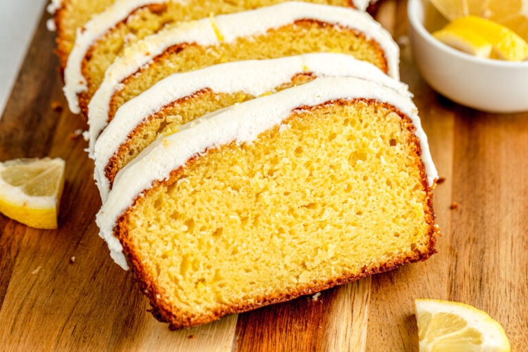 Frosted and sliced Starbucks lemon loaf recipe on a cutting board.