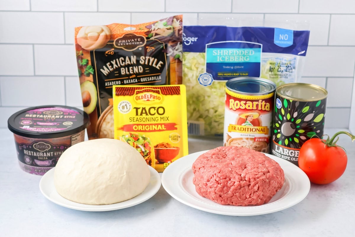 Homemade taco pizza ingredients on counter.