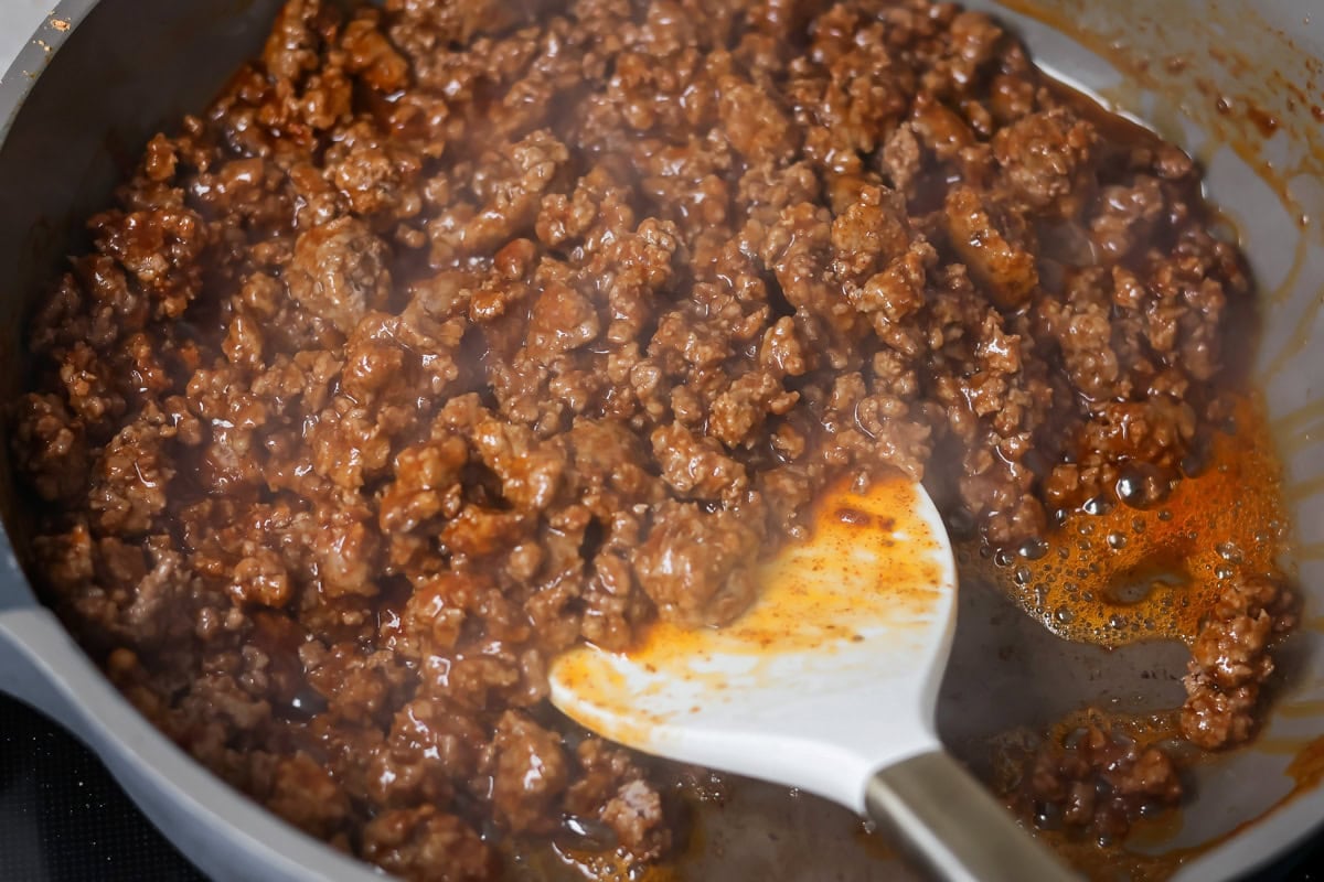 Taco meat cooked in skillet.