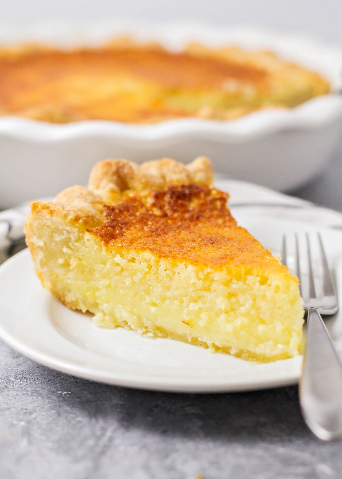 Old-Fashioned Buttermilk pie slice on a white plate.