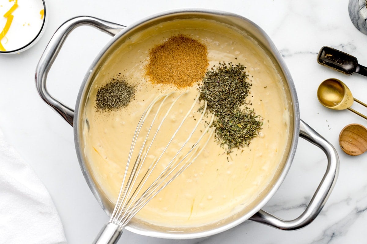 Adding spices to a creamy soup mixture.
