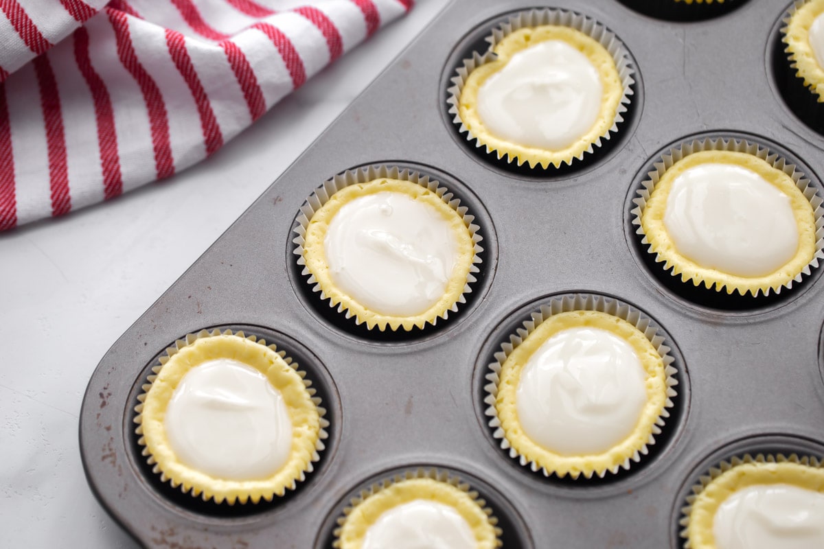 Cheesecake cupcakes in a muffin tin ready to be baked.