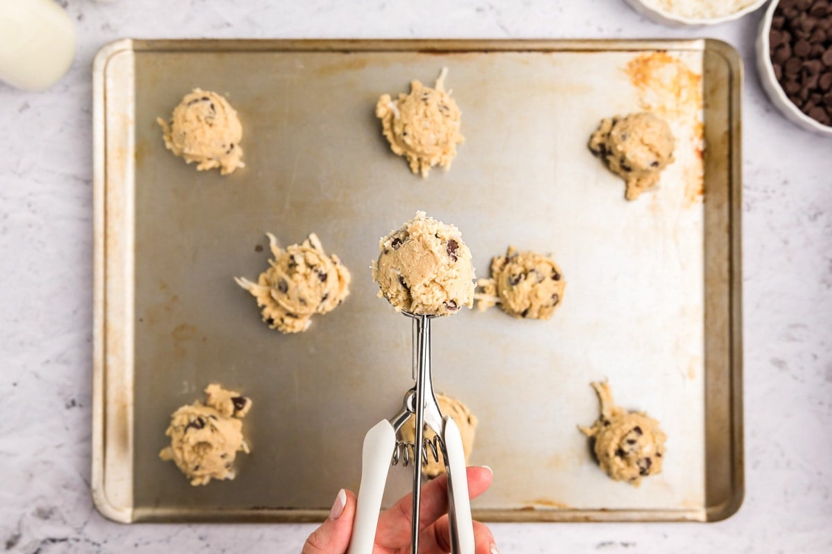 Scooping cookies onto a cookie sheet.