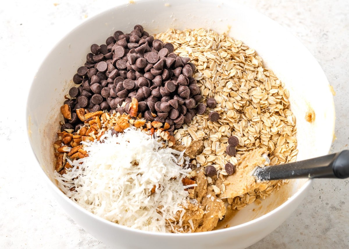 A white bowl filled with cowboy cookies ingredients.