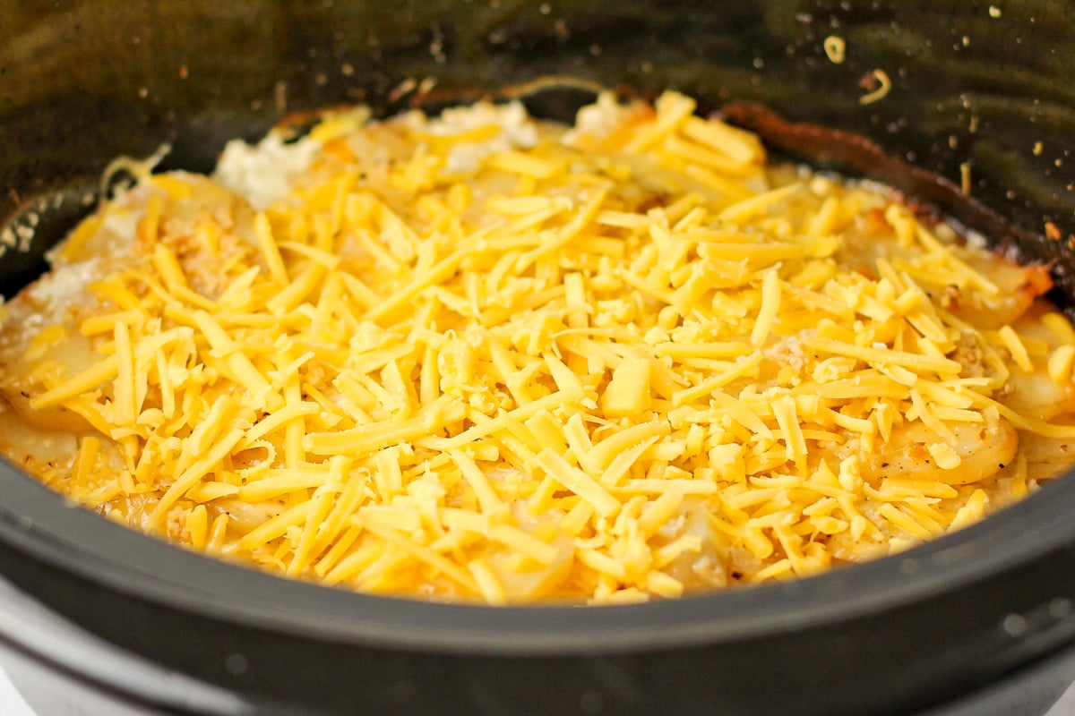 Layers of sliced potatoes topped with shredded cheese.