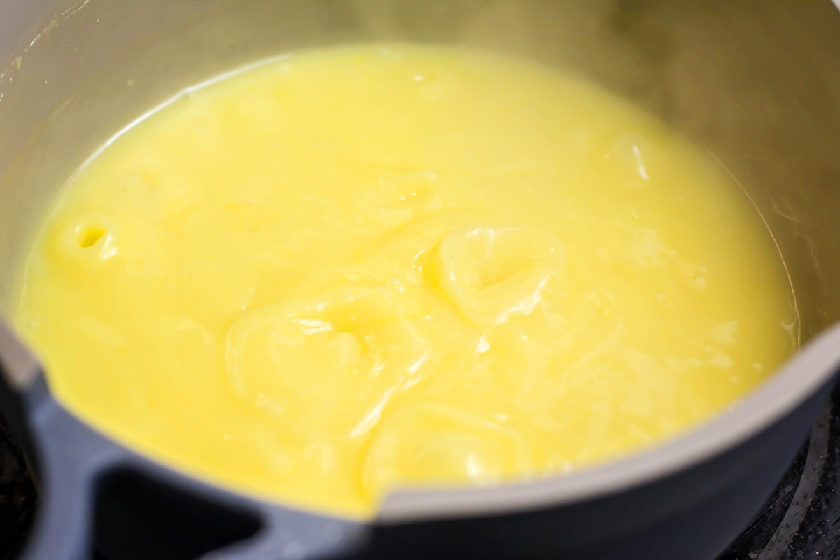 Thickened lemon filling in a pot on the stove.