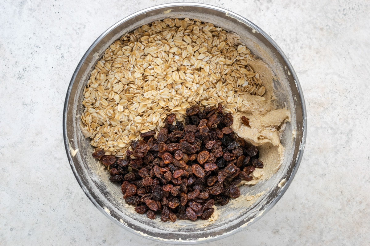 Combining batter ingredients in a bowl for making easy oatmeal raisin cookies.