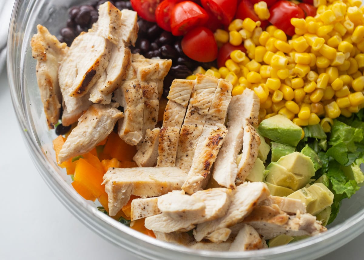 Close up of chopped ingredients for southwest salad in a glass bowl.