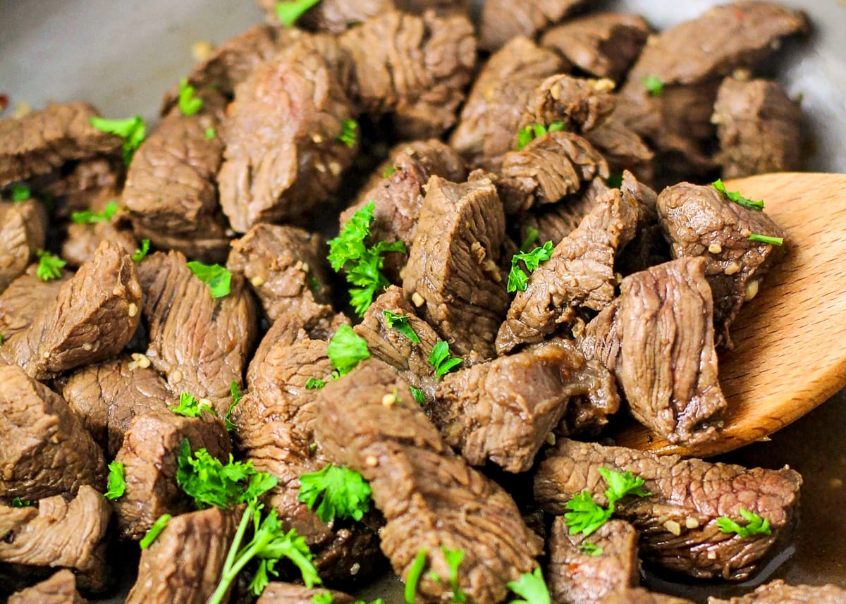 Close up of steak bites seasoned with fresh herbs.