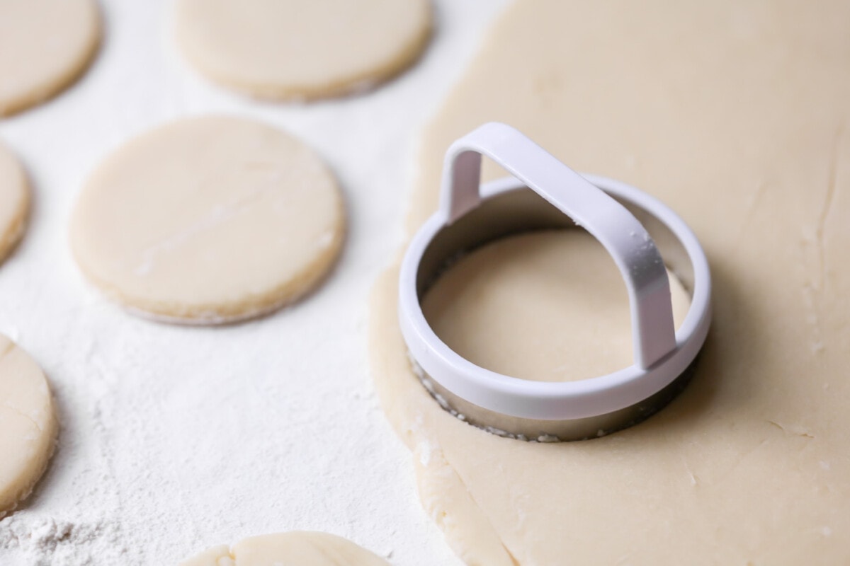 Circle cookie cutter cutting out cookies.