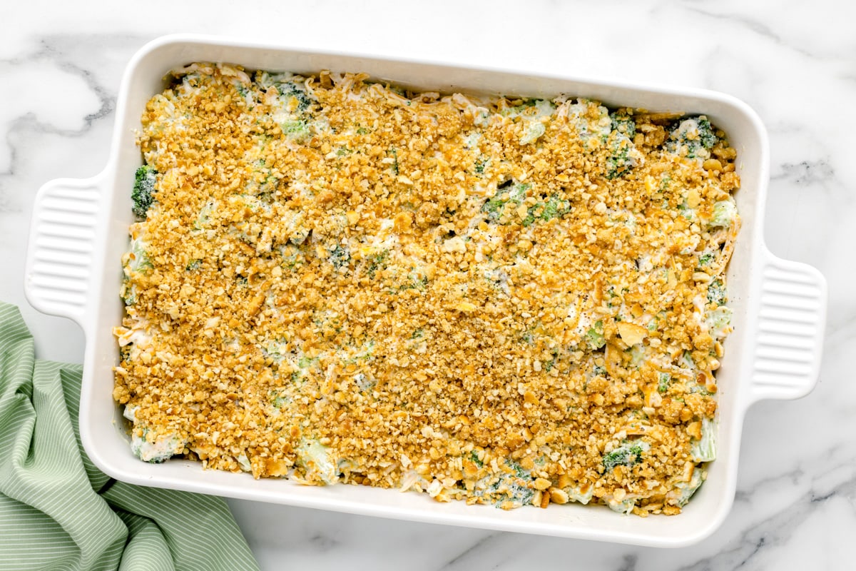 Adding ritz crackers to the top of the broccoli casserole.