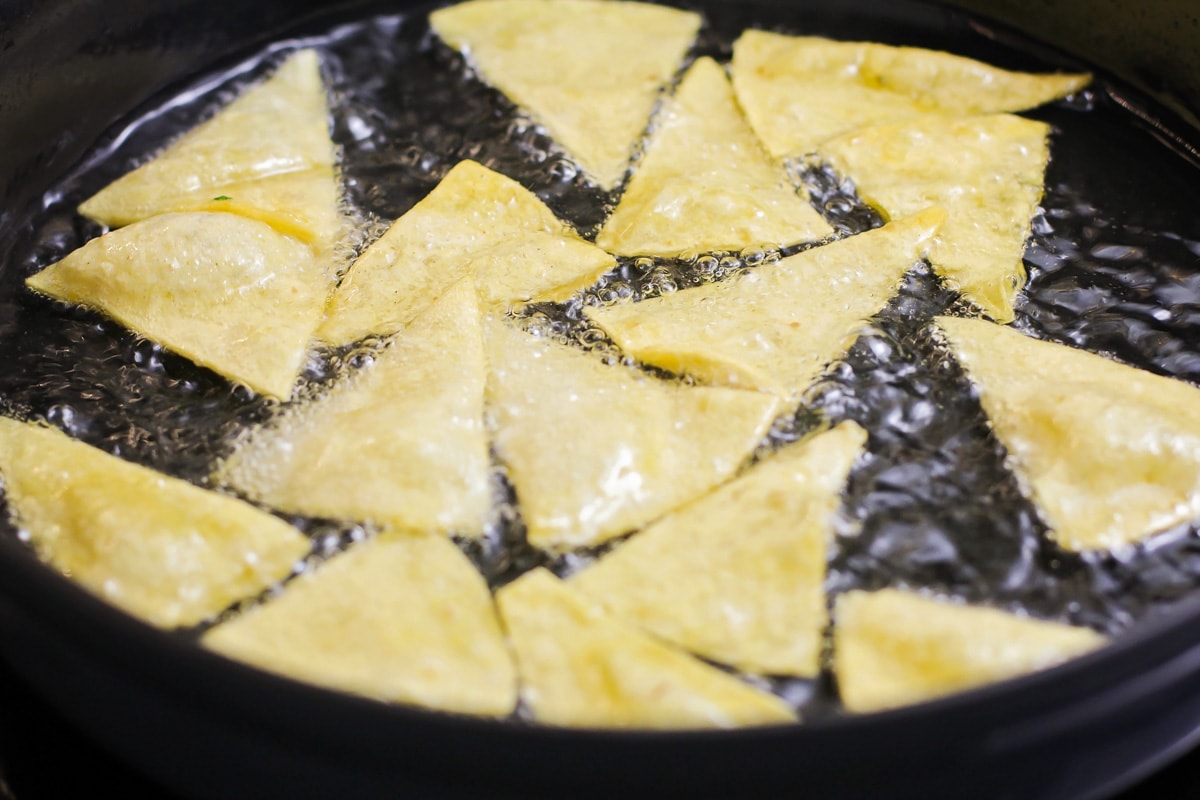 Frying tortillas in a pan of oil.