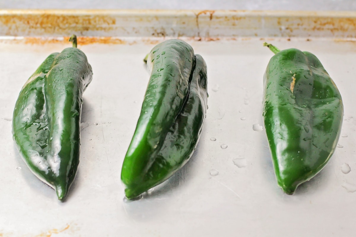 Three green poblano peppers ready to be roasted.