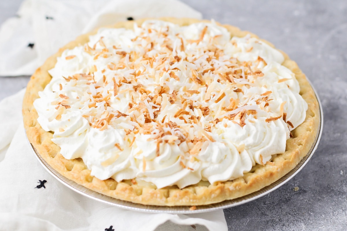 A coconut cream pie topped with whipped cream and toasted coconut.