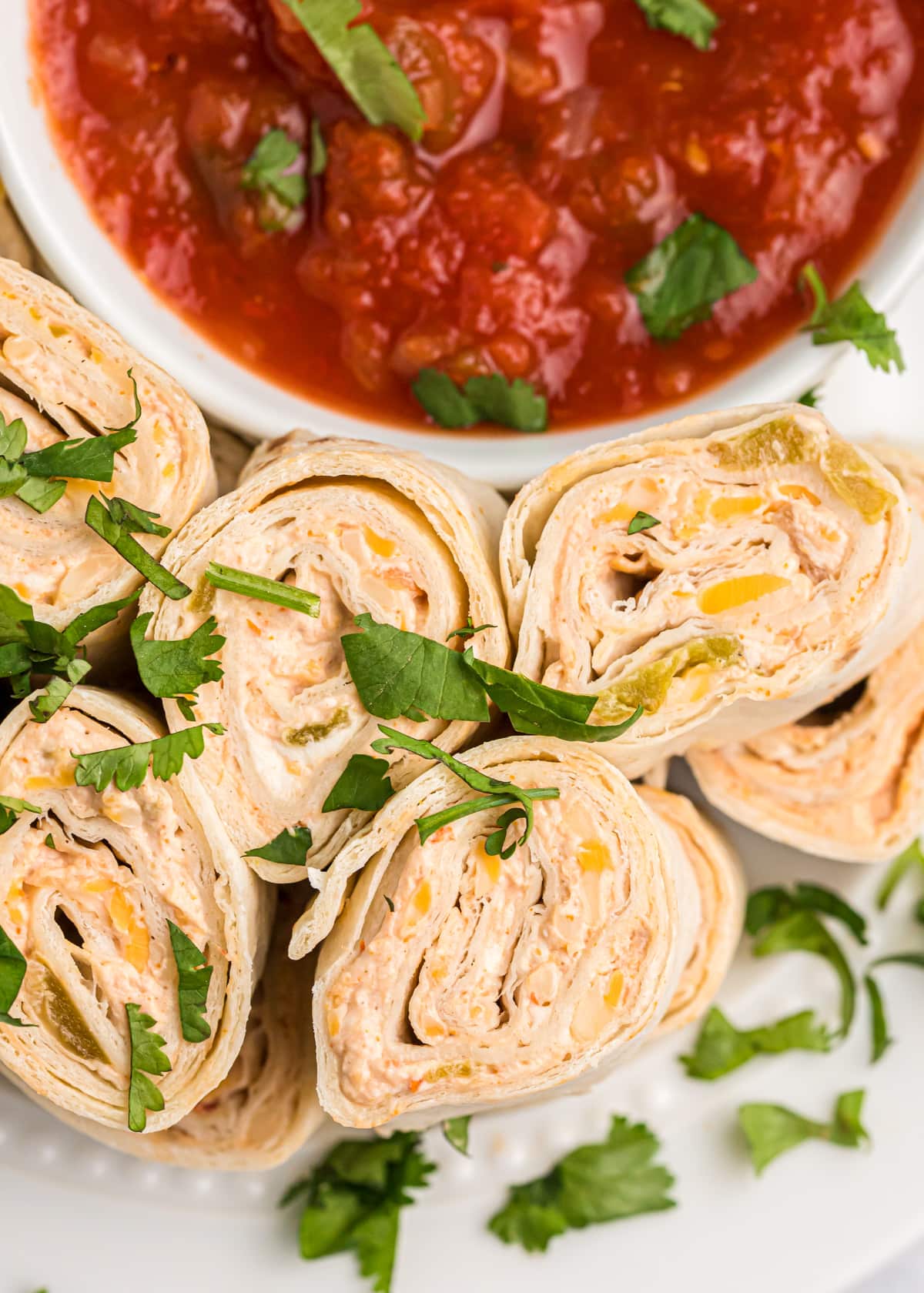 Close up of sliced pinwheels served with salsa.
