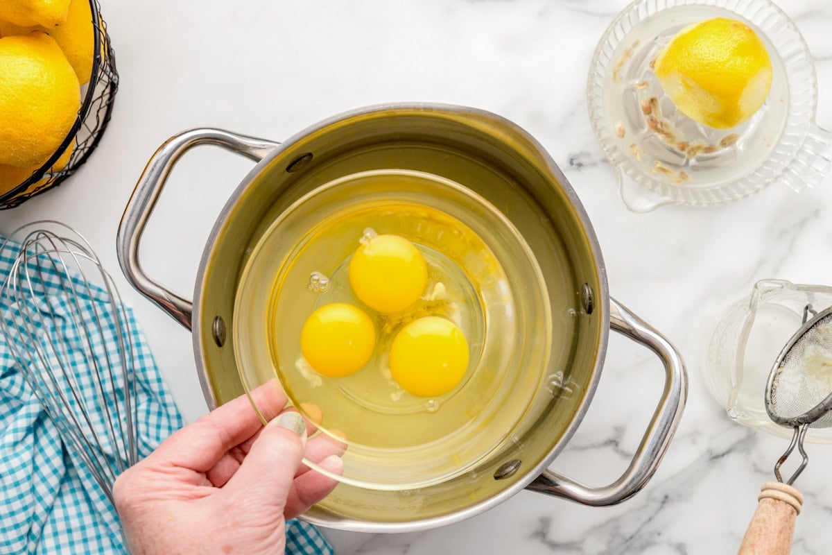 Adding eggs one at a time to make lemon curd recipe.