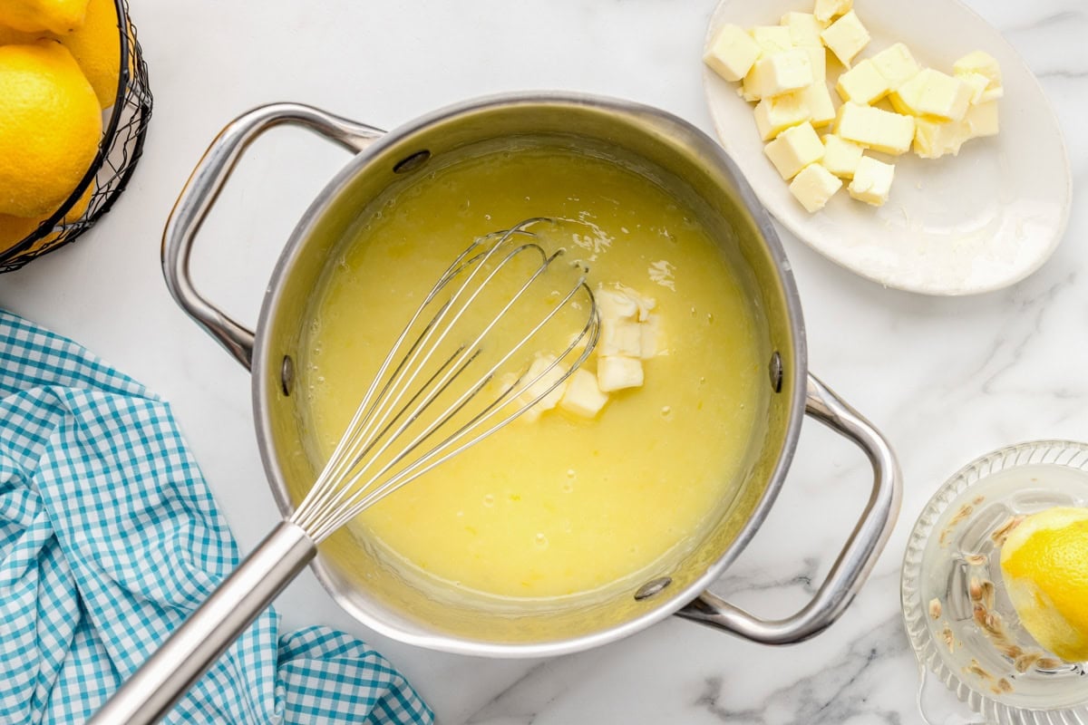 Cooking lemon curd on pot.