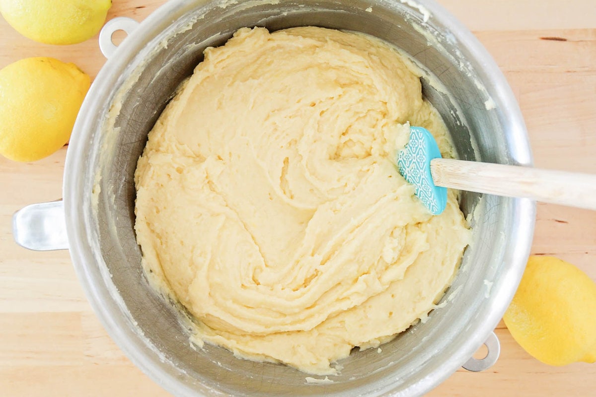 Lemon pound cake batter in mixing bowl and bundt pan for baking.