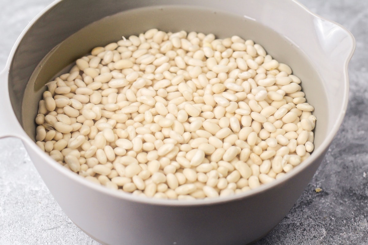 Navy beans soaking in a pot of water.