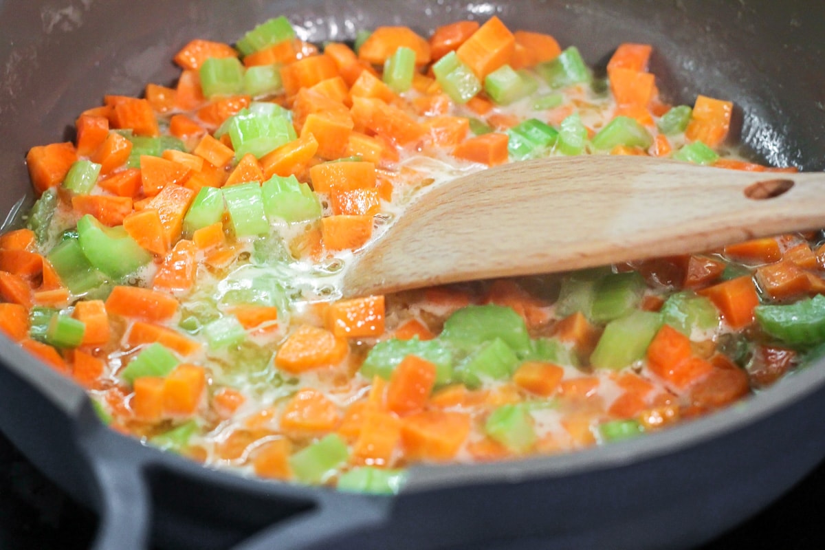 Carrots and celery sautéing in a pan of butter.