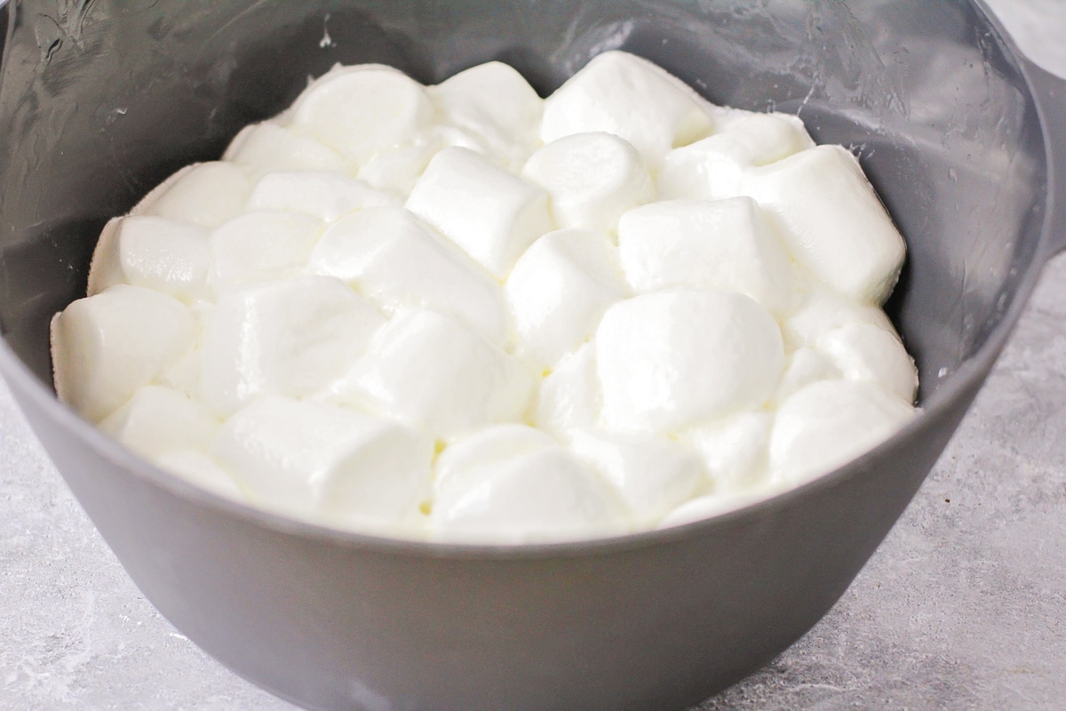 Marshmallows melting in a grey bowl.