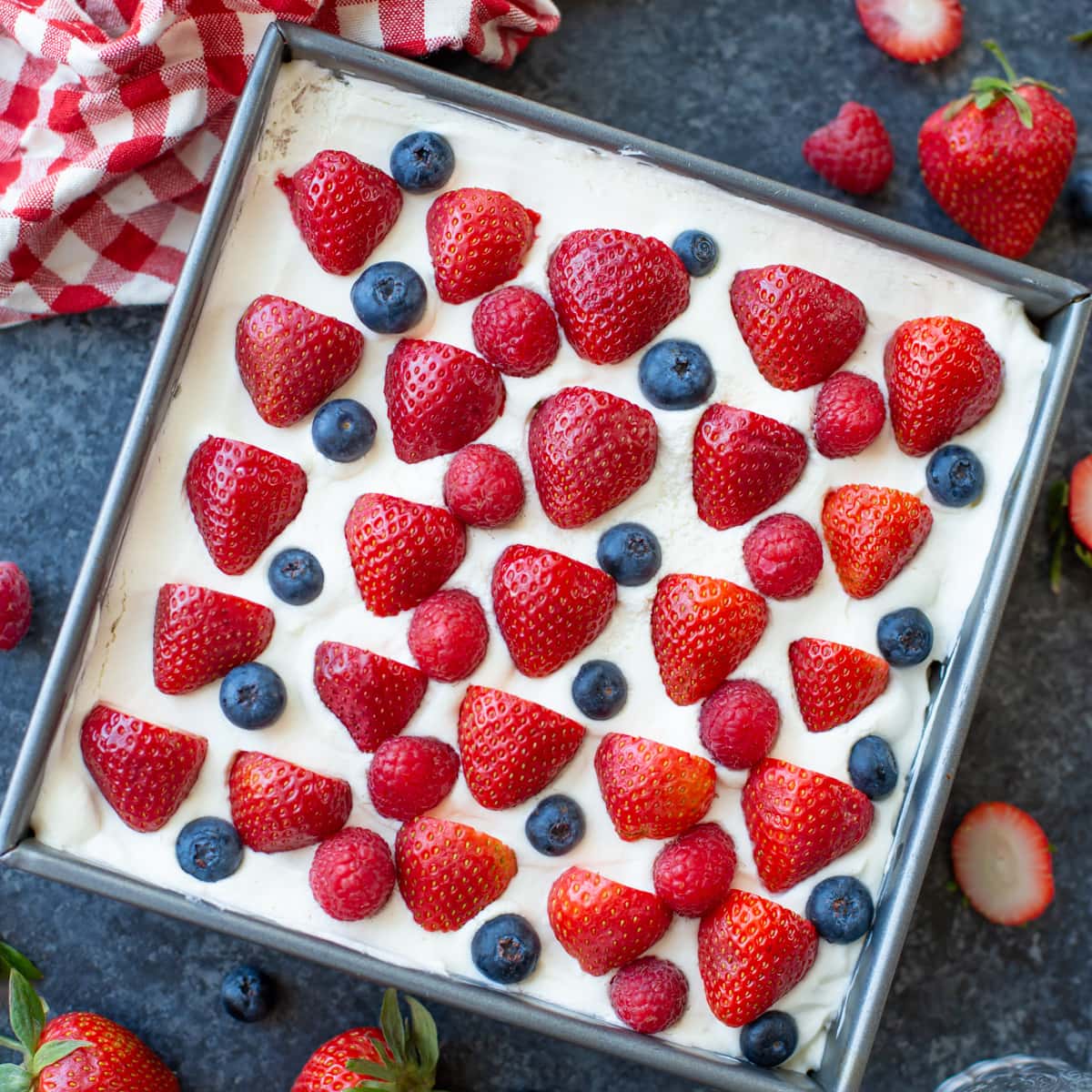 Strawberry icebox cake topped with fresh berries.