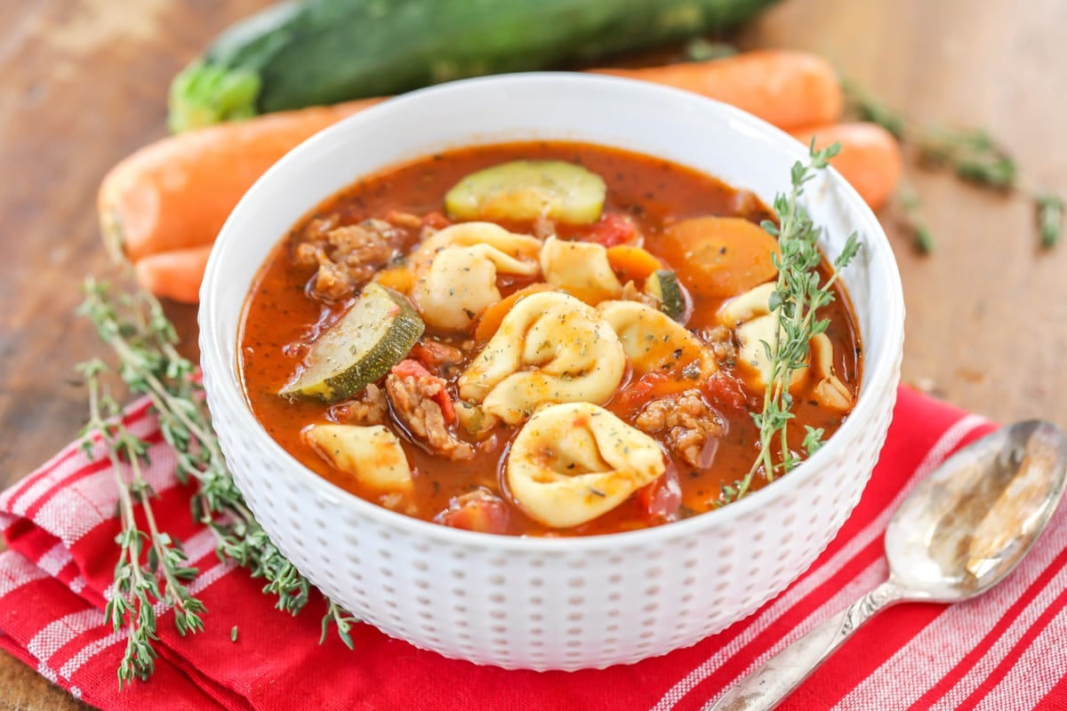 A bowl filled with tortellini soup.
