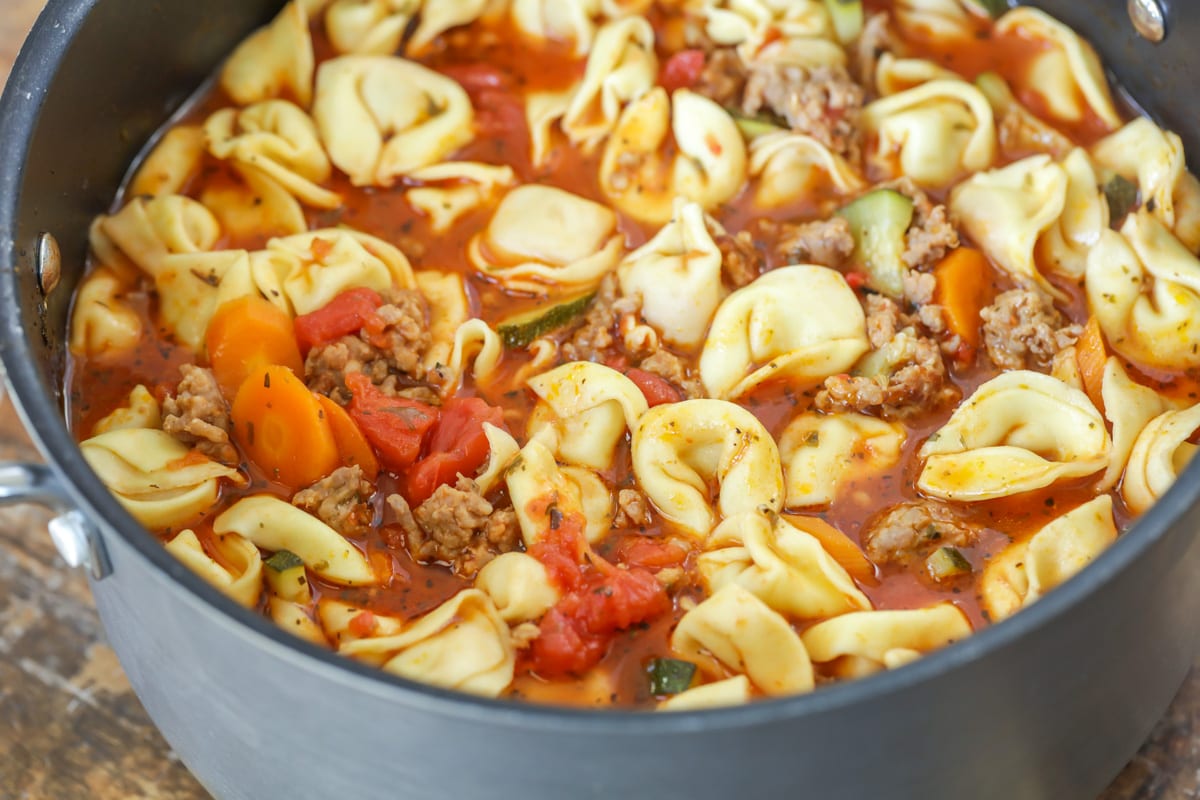 Chunky soup filled with tortellini and veggies in a pot.