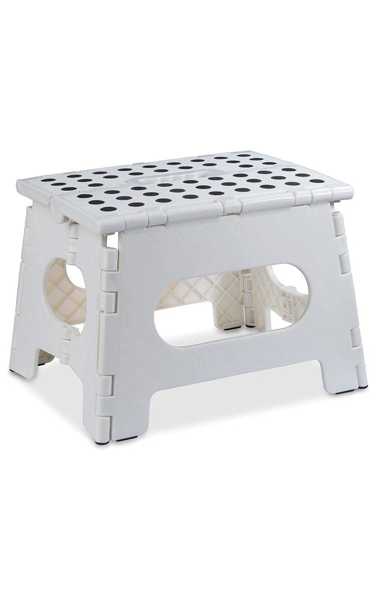 A white stepping stool that can be folded up.