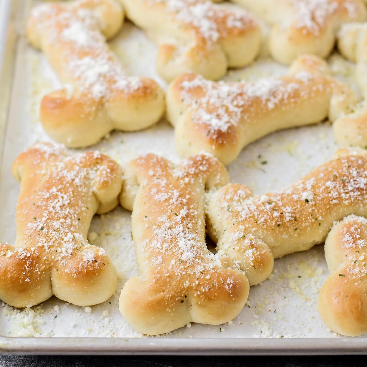 Sprinkling breadsticks with cheese and herbs.