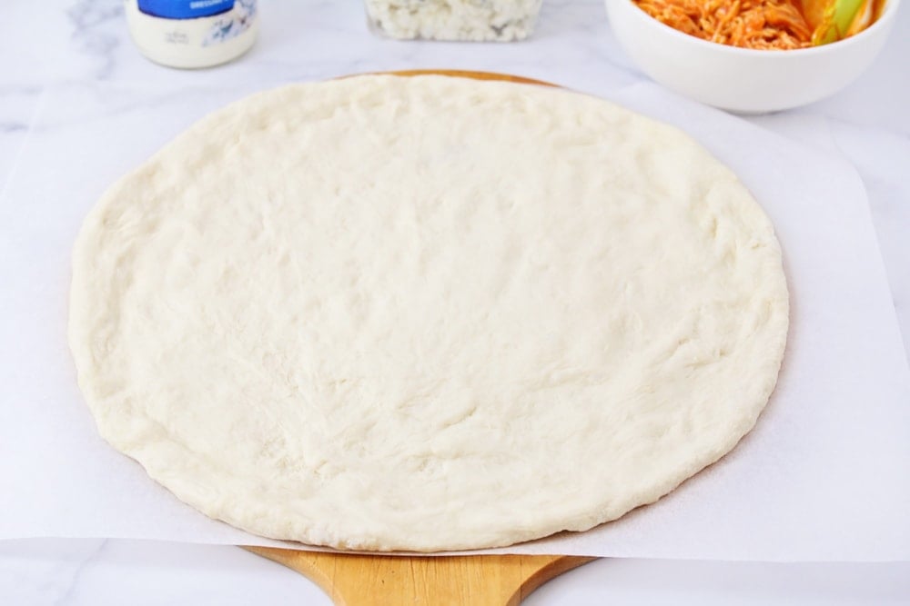 Step by step photos of how to make buffalo chicken pizza.