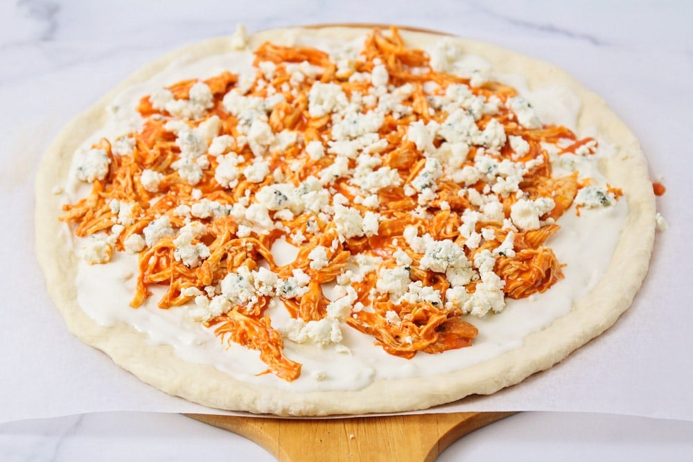 Step by step photos of how to make buffalo chicken pizza.