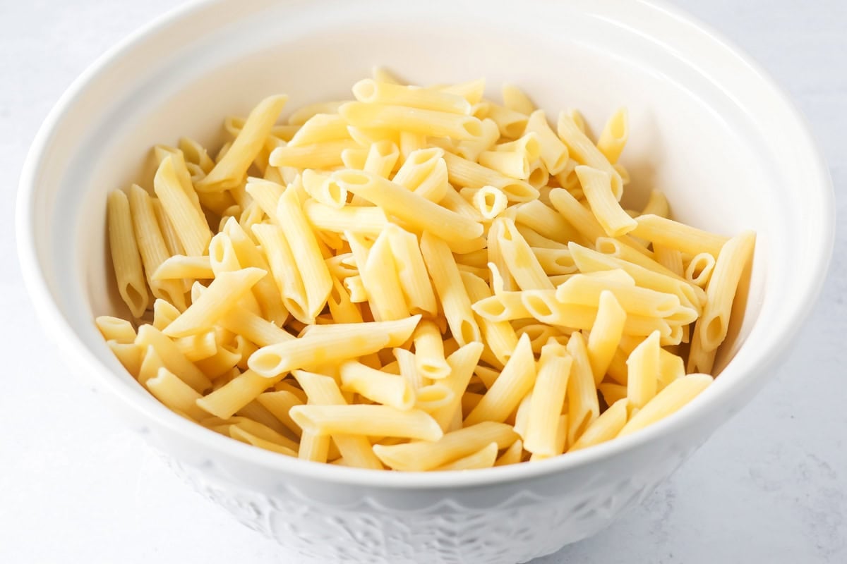 Cooked pasta in a bowl for chicken alfredo bake.
