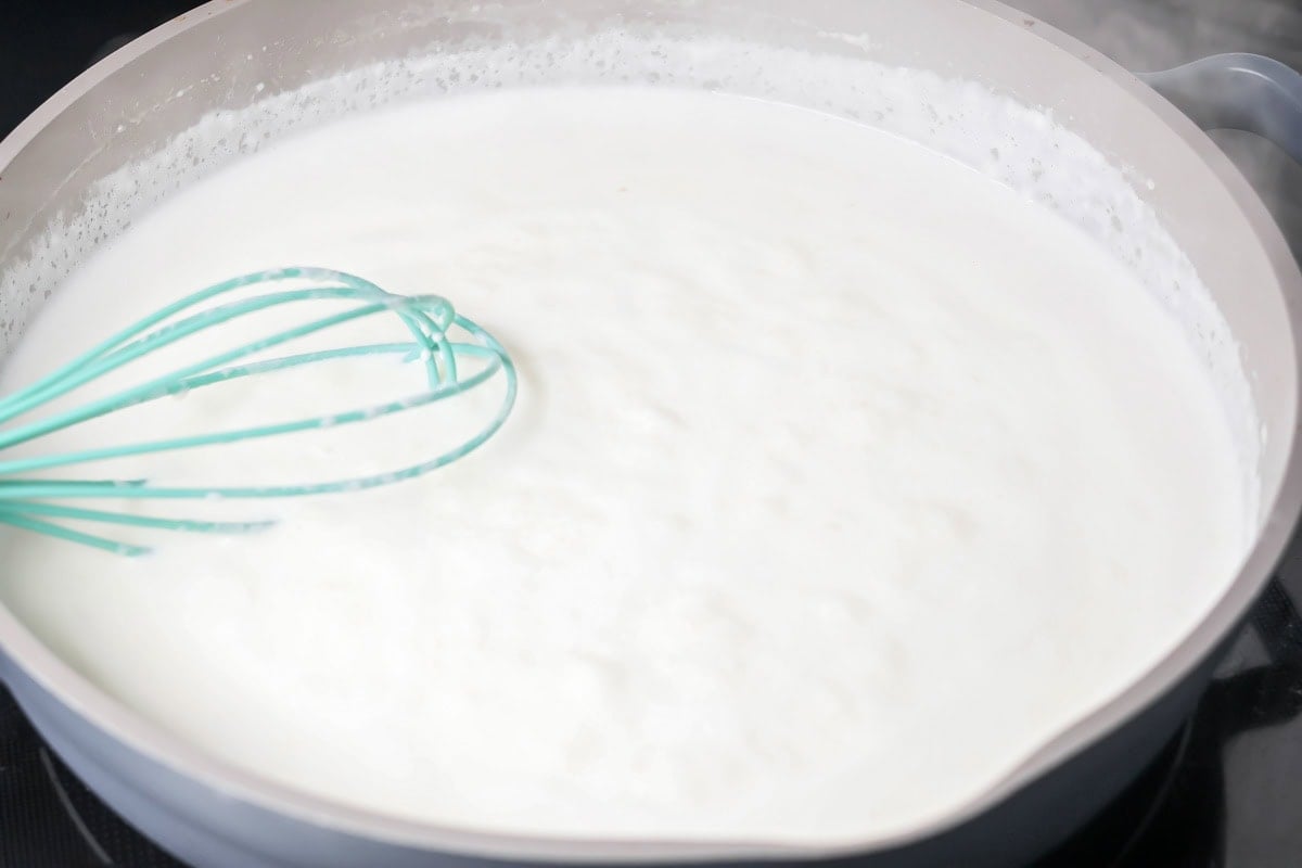 Whisking the sauce for chicken alfredo bake.