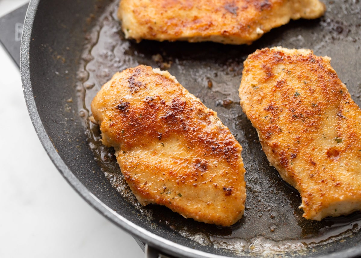 Cooked chicken in skillet for chicken scallopini recipe.