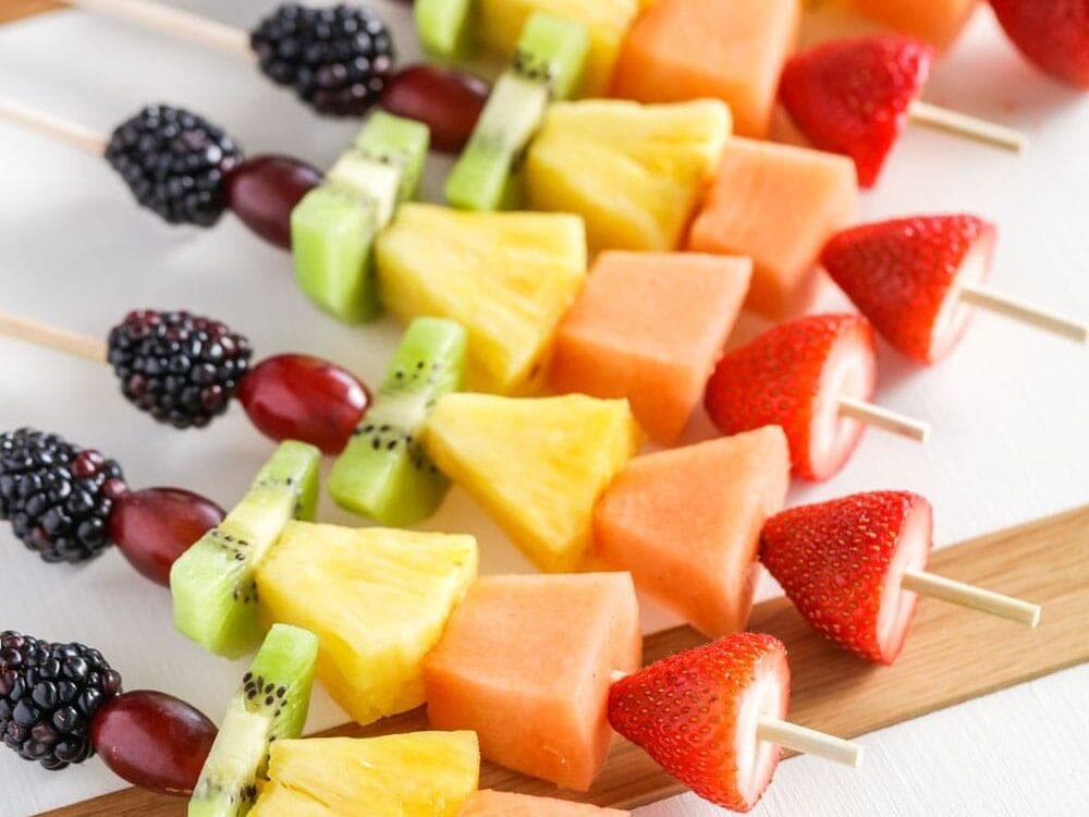 Bite-size pieces of fruit on wooden skewers.