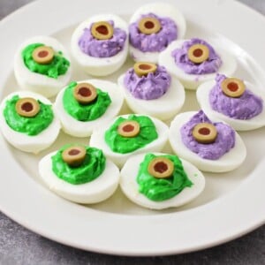 A plate of green and purple Halloween deviled eggs.