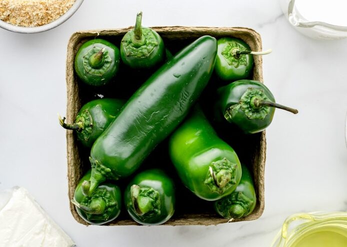 Jalapenos in a container on a kitchen counter.