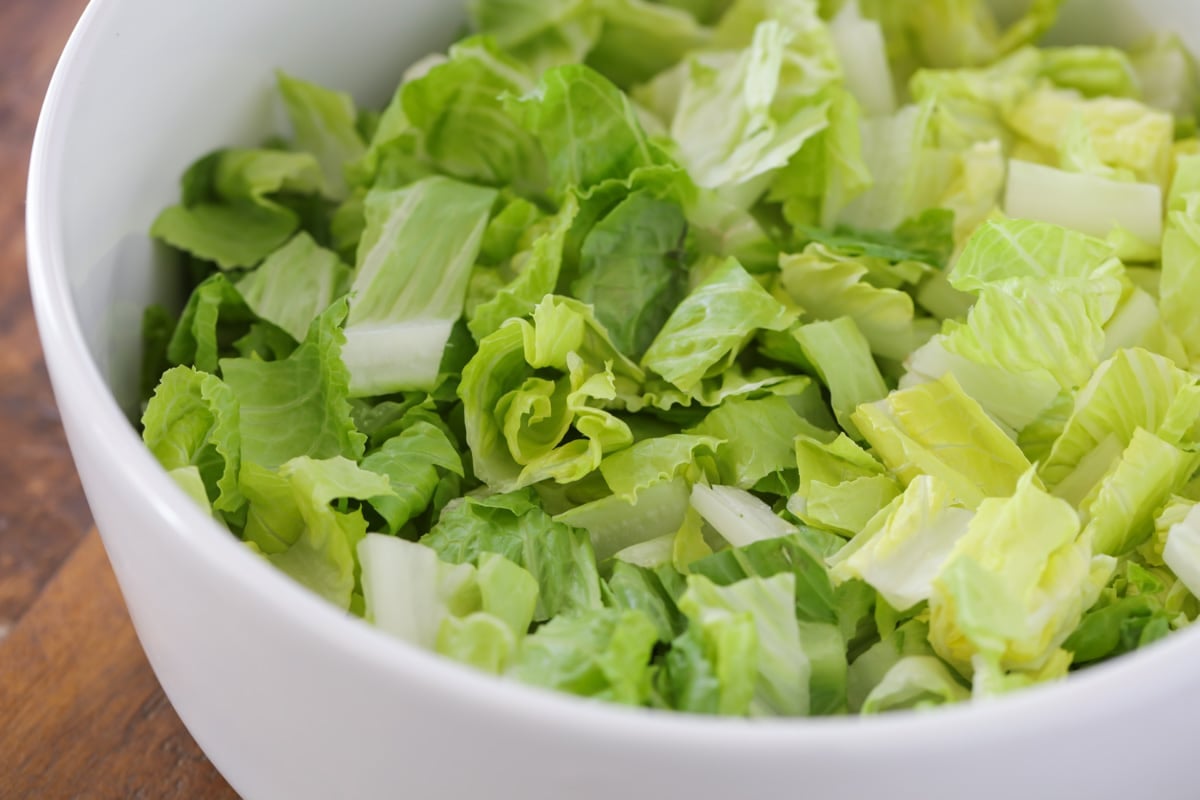 A white bowl filled with chopped romaine lettuce.