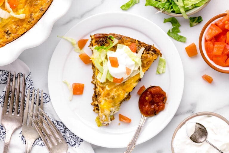 A slice of taco pie served with a spoon of salsa.