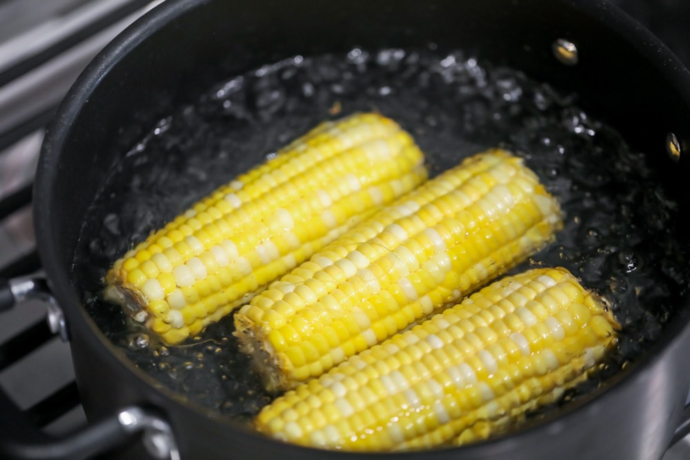 Boiling corn on the cob in a pot.