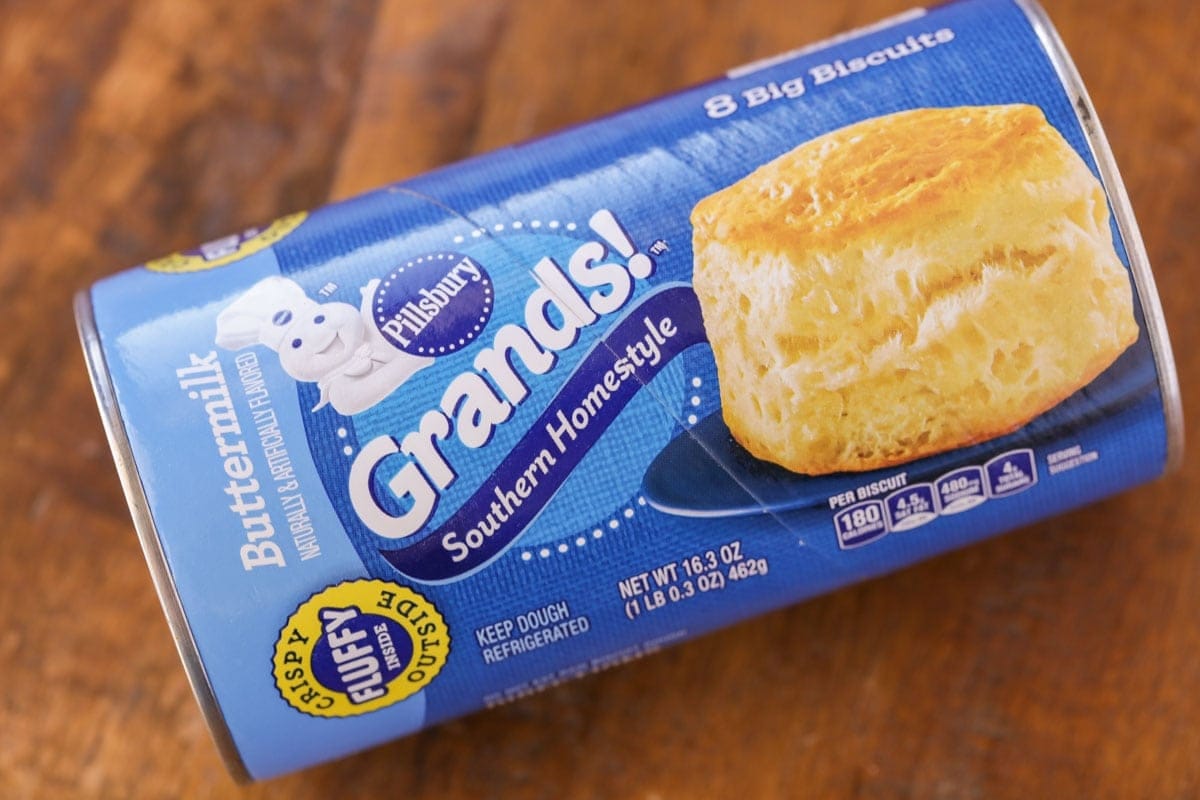 A tube of biscuit dough on a kitchen table.