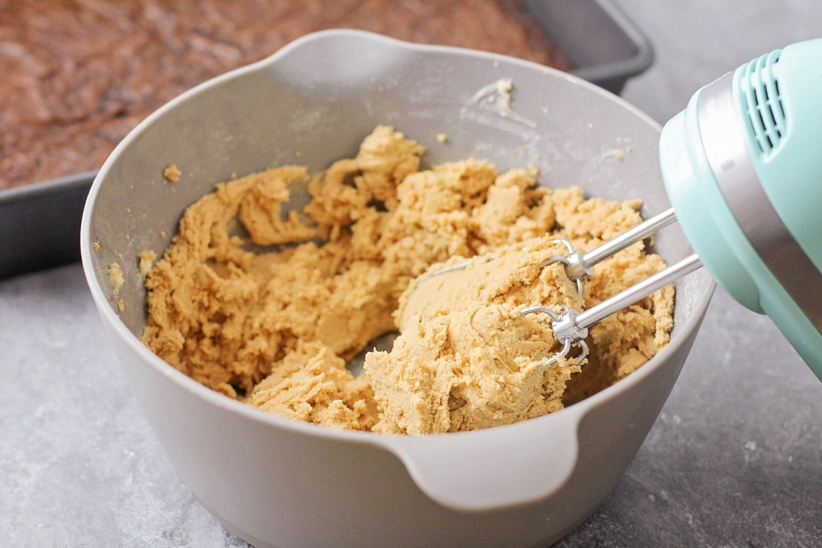 Mixing peanut butter batter in a grey bowl.