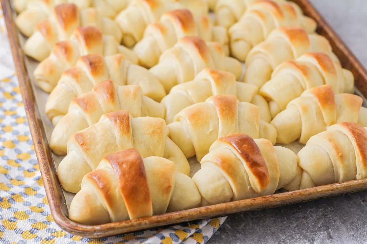 Close up of browned crescent rolls on a baking sheet.