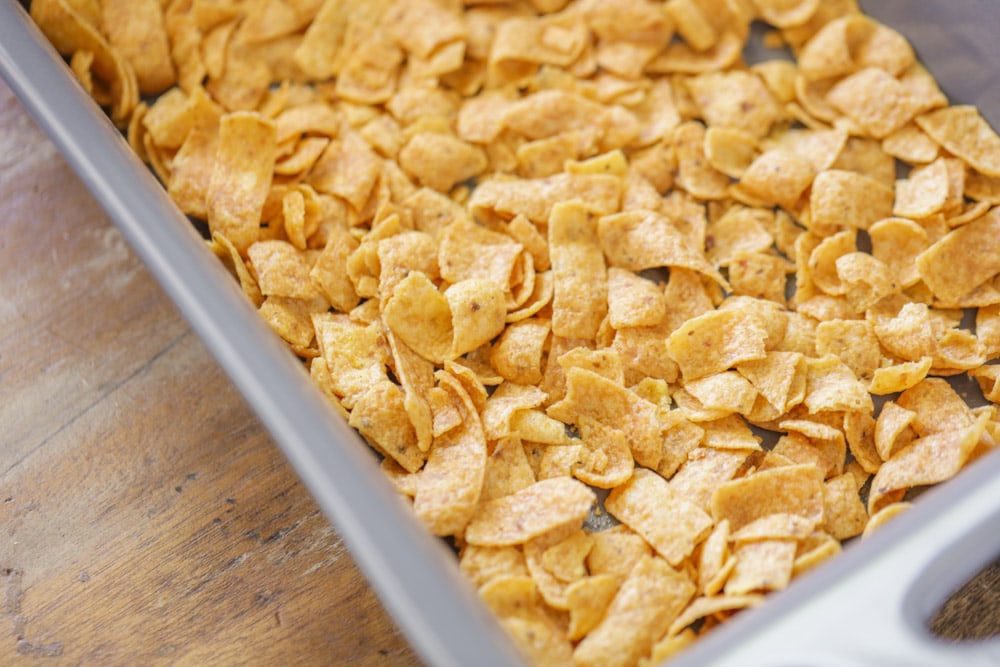 Fritos in the bottom of a baking dish.
